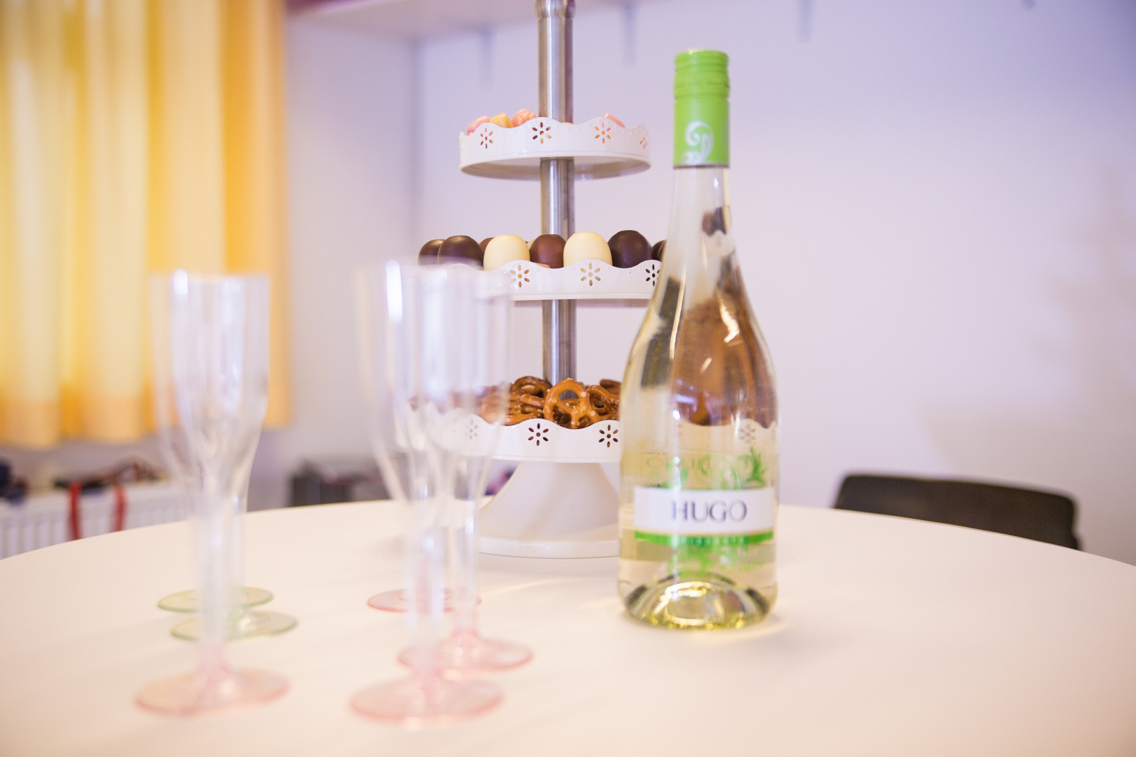 Stehtisch mit Gläsern, Sekt und Süßigkeiten